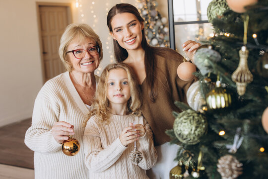 Three Generations Decorating Christmas Tree at Home
