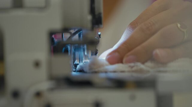 CloseUp of Hands Sewing Soft Fabric with Machine