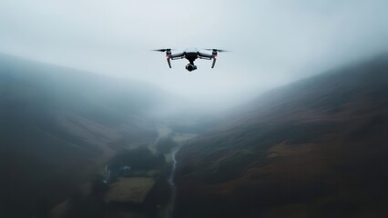 Fototapeta premium A drone hovers over a valley shrouded in mist, capturing a wide aerial landscape
