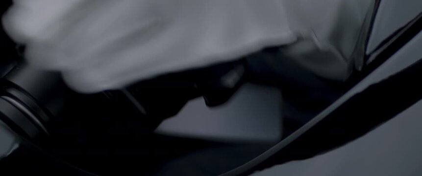 Close-up of a race car driver in a driving fast on a racing track, evening race