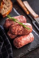 Photo of italian sausage salsiccia on cutting board on black table.