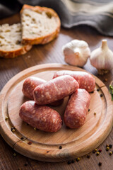 Photo of italian sausage salsiccia on cutting board on wooden table.