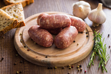 Photo of italian sausage salsiccia on cutting board on wooden table.