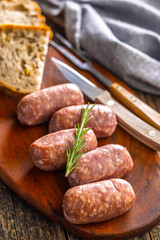 Photo of italian sausage salsiccia on cutting board on wooden table.