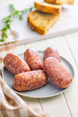 Photo of italian sausage salsiccia on plate on white table.