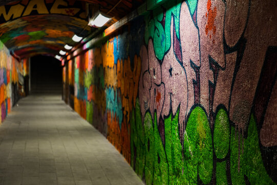 Explore urban art inside this tunnel, showcasing vibrant graffiti and colorful street expressions, perfect for creative projects needing an edgy, modern feel