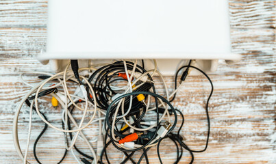Tangled cords and cables on a table. Space organization concept.