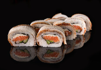 Philadelphia rolls with eel, salmon, cucumber, and avocado on a reflective surface