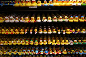 Colourful display of rubber ducks arranged neatly on store shelves, each designed with different...