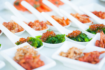 red caviar close-up in white spoons on banquet