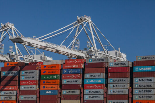 Global trade infrastructure at Port of Oakland with stacked containers and cargo cranes