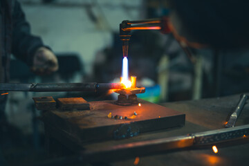 Workers of the blacksmith's workshop heat the metal part to red, for further forging and giving the desired shape. High quality photo