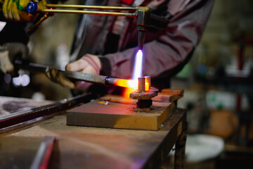 Workers of the blacksmith's workshop heat the metal part to red, for further forging and giving the desired shape. High quality photo
