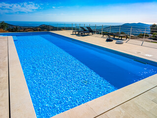 Fototapeta premium Infinity Pool Overlooking the Mediterranean Sea and Hills at Sunset – Luxury Villa View