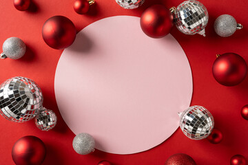 Vibrant holiday scene with red and silver ornaments framing a soft pink circle, evoking festive mood and greeting for Christmas and New Year events and promotions