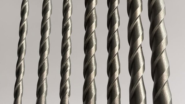 Alignment of seven tungsten carbide-tipped masonry drill bits against a white background: Represents construction tools, hardware, engineering, and DIY repair projects