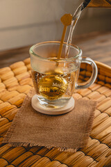 Pouring Hot Water Over Tea Infuser in Glass Mug