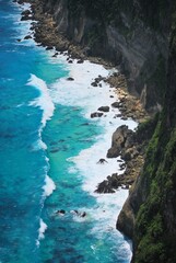 Turquoise waves hitting the cliffs of Nusa Penida, Bali, Indonesia