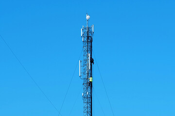 Obraz premium Maintenance staff at the work. High-altitude work. Worker repair cell tower
