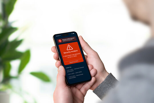 Smartphone displaying red GDPR security alert about data breach with report link to DPO, representing data incident notification and transparency