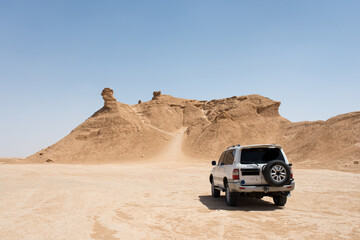 Off road car near Ong Jemel, the Camel Neck Rock. Sahara Desert near Tozeur, Tunisia.