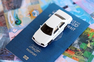 Kuwaiti dinar currency money bills and car with passport close up. The concept of car ownership
