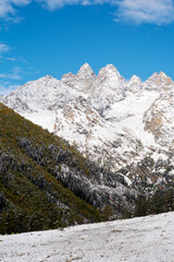 A stunning contrast in Gwandra where snow-capped peaks pierce the blue sky while the foreground valley blazes with autumn's golden embrace.