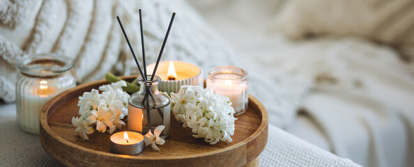 Banner. Concept of cozy home space for meditation, relaxation. Spiritual aura cleansing routine. Spring hyacinth blossom scent. Burning candles, aroma fragrance natural organic diffuser, bamboo tray