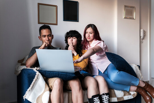 Friends engaged in online community project at living room