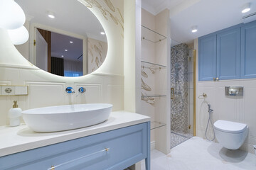 A modern bathroom showcases a sleek sink and elegant mirror, complemented by a stylish shower area. Warm lighting enhances the inviting atmosphere, creating a relaxing space.