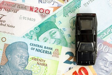 Nigerian naira currency money bills and toy car close up. The concept of car ownership