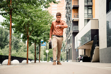 Confident young businessman checking time while walking through modern urban city street with professional demeanor