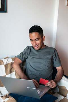 Relaxed man browsing online store and completing digital payment wit credit card