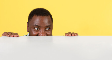 Hungry African American Millennial Man Looking At Empty Table Dreaming About Food Over Yellow Studio Background. Temptation, Great Offer Advertisement Concept. Panorama