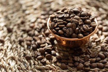 Close-Up of Coffee Beans in a Copper Mini Cup on a Brown Textured Surface
