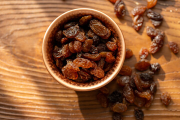 Dried Raisins in a Copper Bowl on a Brown Wooden Table
