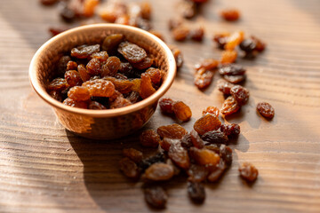 Dried Raisins in a Copper Bowl on a Brown Wooden Table
