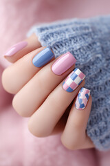 Female hand showing fashionable pastel pink and blue nail art
