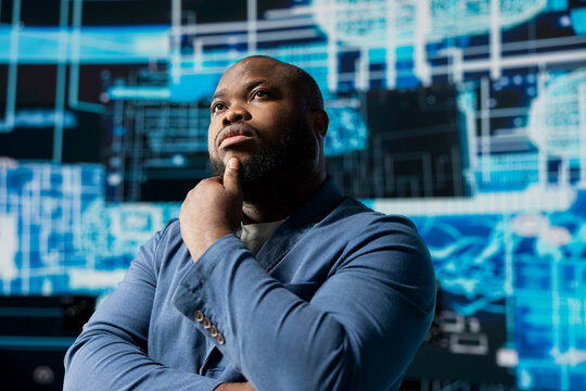 Tech savvy African American specialist analyzing big data AI brain using cloud computing tools and advanced programming for virtual assistant development and automation systems. Cybernetics.