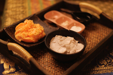 Traditional thai massage ingredients: natural creams and scrubs on woven tray