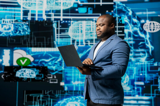 Modern african american businessman working in AI data visualization environment, illustrating computer science, and automation tools for machine learning, neural networks systems. - Powered by Adobe