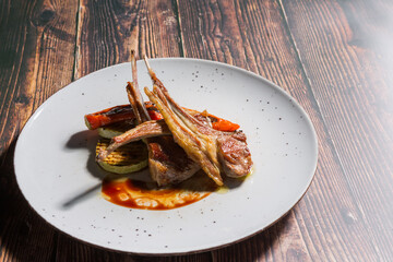 Lamb chops with grilled vegetables served on white plate