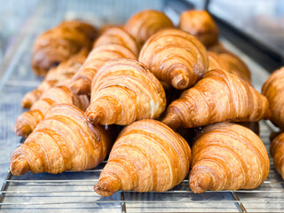 Golden Croissants on Cooling Rack in Bakery Display