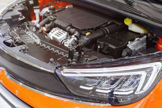 Open hood of a new car revealing engine in auto shop