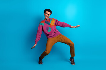 Cheerful young man posing in colorful clothing against a vibrant backdrop expressing joy and positivity