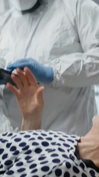 Vertical Video Doctor in biohazard lab conducts medical trial on a contagious patient, studying disease transmission, symptoms and antiviral drug effectiveness to develop treatments in virology