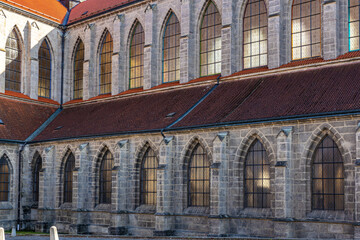 Gothic cathedral exterior with arched windows and stone facade at sunset
