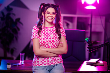 Adorable female content creator in a stylish casual outfit hosting an online broadcast from her personalized workspace.