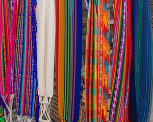 Brightly colored fabric hammocks are sold at the Plaza de los Ponchos Artisans market in Otavalo,...