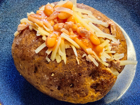 Nottingham,England,December 21, 2024.An typically English dish.These are jacket potatoes,whole potatoes baked in the oven with the peel and then stuffed.The potato is cut in half and topped with beans